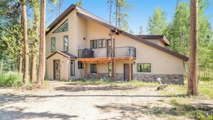 A two-story house with a balcony, surrounded by trees. - Two-story dog-friendly getaway with WiFi, wood-burning fireplace, & washer/dryer (Fraser)
