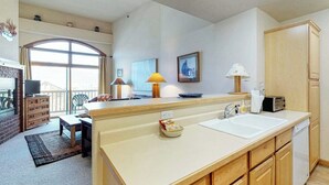Une cuisine dotée d’un grand îlot central, d’un évier, d’une cuisinière et d’un coin repas avec une table et des chaises.
