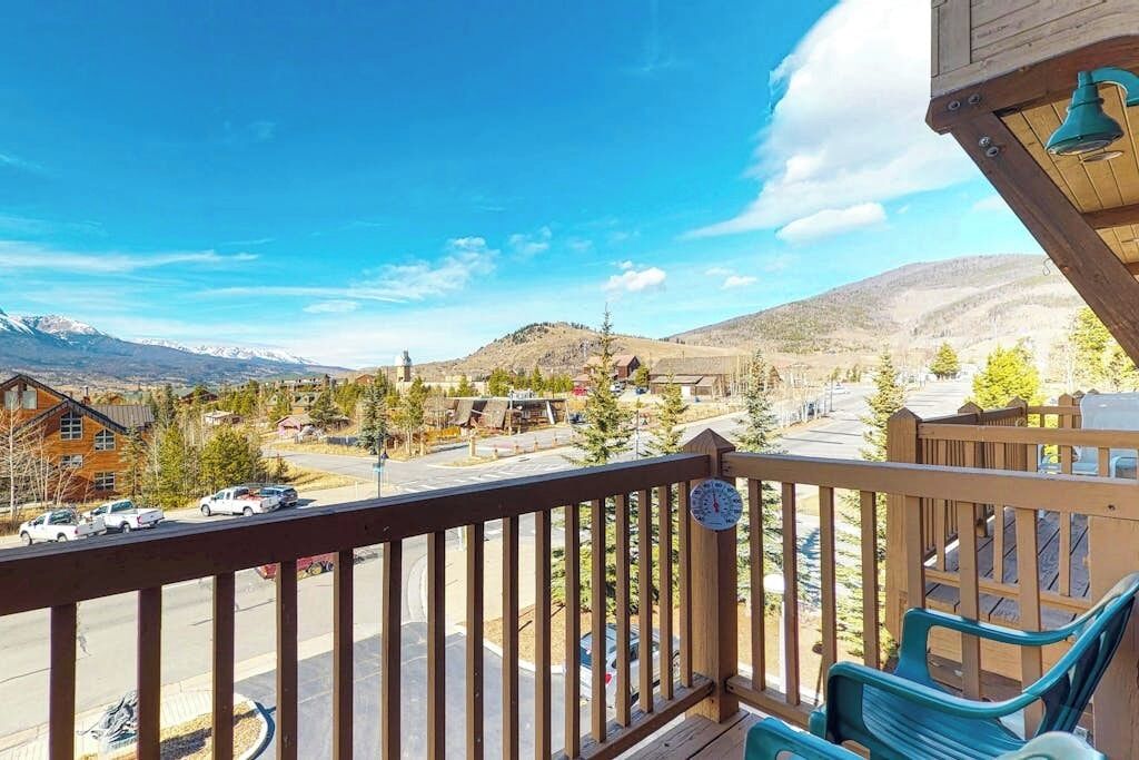 Un balcon donnant sur la ville, avec une balustrade en bois et une horloge.