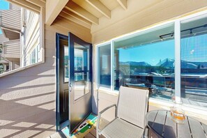 Ein Balkon mit Stuhl, Tisch und Bergblick.