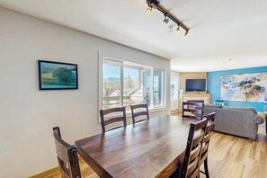 Ein Essbereich mit Holztisch und Stühlen, einer Couch und einem Fernseher.