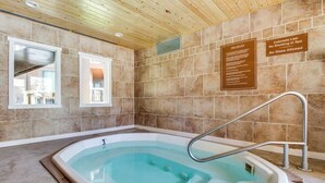 A spa area with a hot tub, wooden ceiling, tiled walls, and a window. - Cozy condo w/ private balcony, shared pool, & hot tub - close to golf & slopes (Keystone)