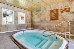 A spa area with a hot tub, wooden ceiling, tiled walls, and a window. - Cozy condo w/ private balcony, shared pool, & hot tub - close to golf & slopes (Keystone)