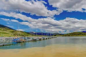 Ein Yachthafen mit vertäuten Booten, ein klarer Himmel und Berge im Hintergrund.