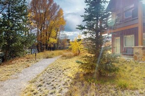 A pathway leading to a building with a stone facade, surrounded by trees with autumn foliage. - End-Unit Condo w/Beautiful Blue River & Mountain Views, Free WiFi, & Deck (Silverthorne)