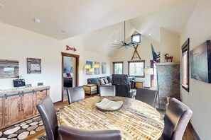 A dining area with a round table, chairs, and a wooden cabinet.