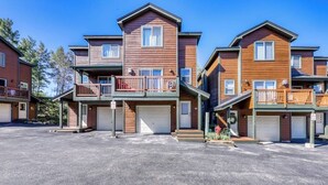 A multi-story residential building with a central entrance, balconies, and attached garages. - Mountain family townhome w/ fireplace, private balcony & beautiful views (Silverthorne)