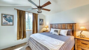 A bedroom with a bed, a ceiling fan, a nightstand with a lamp, and two posters on the wall. - Mountain family townhome w/ fireplace, private balcony & beautiful views (Silverthorne)