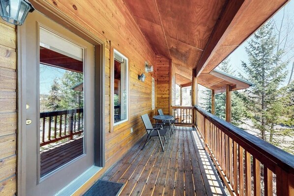 A wooden deck with a table and chairs, a door with glass panels, and a view of trees. - Gorgeous Townhouse w/Free WiFi, Private Washer/Dryer, Lake Views - Near Keystone (Dillon)