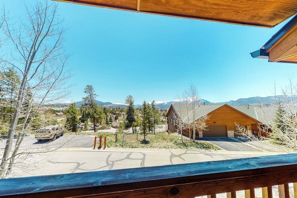 A mountain view with a wooden cabin and a paved driveway.