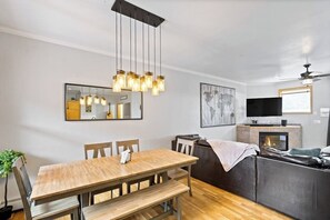 Ein moderner Wohnbereich mit Essbereich, einer Couch, einem Kamin und einem Fernseher.
