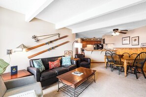 Ein modernes Wohnzimmer mit einer Couch, einem Couchtisch und einem Essbereich mit Stühlen.
