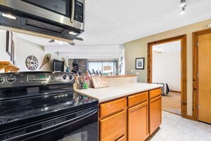 Eine Küche mit Herd, Mikrowelle und Holzschränken.
