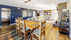 A modern living room with a dining table, sofas, and a kitchen in the background. - Mountain View Condo with Private Balcony, Gas Fireplace & Free WiFi (Silverthorne)