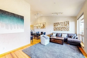 Ein modernes Wohnzimmer mit einer Couch, einem Couchtisch und einem Kunstwerk an der Wand.