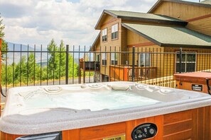 A hot tub in front of a wooden house with a metal fence. - Mountain view home with high-speed WiFi and washer/dryer (Silverthorne)