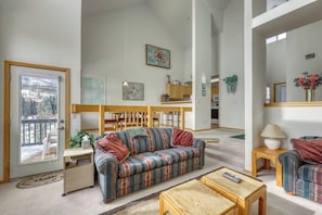 Ein geräumiges Wohnzimmer mit einer Couch, einem Couchtisch und einem Essbereich mit Stühlen und einem Tisch.
