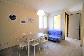 Ein Essbereich mit Tisch, Stühlen, einer Couch und einer Tür.