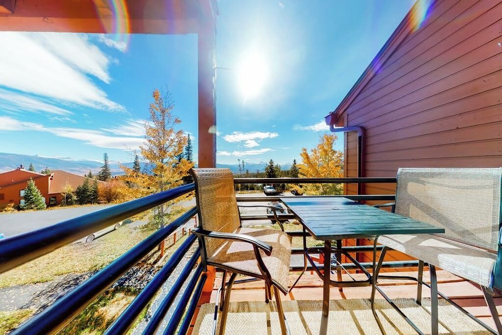 Ein Balkon mit Gartenmöbeln, Blick auf die Berge und einen klaren Himmel.