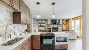 A modern kitchen with a built-in oven, a microwave, and a dishwasher. - Cozy condo with fireplace, pool, & hot tub - near trails (Silverthorne)