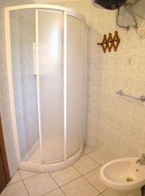 A bathroom with a shower enclosure, a sink, and a towel rack. - Holiday apartment with air conditioning and terrace (Rosolina Mare)
