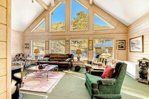 Ein großzügiger Loft-Raum mit hohen Decken, großen Fenstern und einer gemütlichen Sitzecke mit einer Couch und Sesseln.
