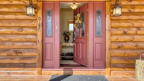 A wooden log cabin with a red door, a number '0157' on the door, and a small porch area. - Waterfront home on the Rio Grande with washer/dryer, deck, & amazing views (South Fork)