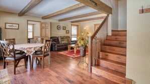 A spacious living area with a wooden staircase, a dining table with chairs, a sofa, and a coffee table. - Waterfront home on the Rio Grande with washer/dryer, deck, & amazing views (South Fork)
