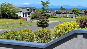 Un quartier résidentiel avec des maisons, un ciel dégagé et des montagnes en arrière-plan.