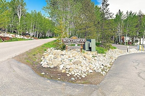 Schild für Winterwood mit Privatgrundstück-Hinweis, umgeben von einer begrünten Fläche mit Steinen und Bäumen.