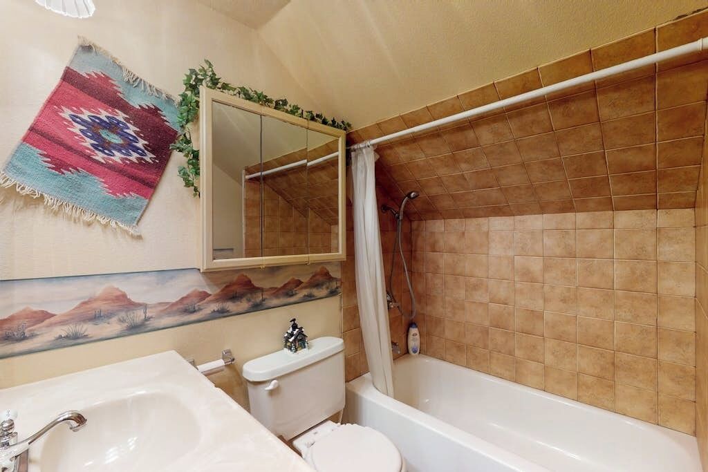 Ein Badezimmer mit Badewanne, Toilette, Waschbecken und Spiegel.