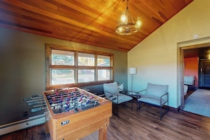 A room with a wooden ceiling, a foosball table, a window with a view, and a chair. - Mountain View Home w/ jetted tub, air hockey, foosball near Wolf Creek (Del Norte)