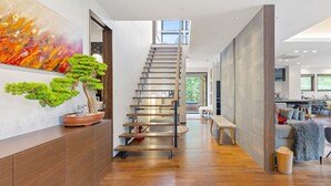 A modern interior with a wooden floor, a staircase, a dining area, and a kitchen. - Mineta - Rusutsu Chalets (Rusutsu)
