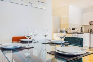 A dining table set with plates, glasses, and cutlery in a modern kitchen setting. - Charming Apartment for Friends, Couples and Families in London - Hackney 3 (London)
