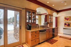 A kitchen with wooden cabinets, a dishwasher, and a large window. - Inviting Condo Near Town w/ Jetted Tub, Full Kitchen, Balcony & Free WiFi (South Fork)