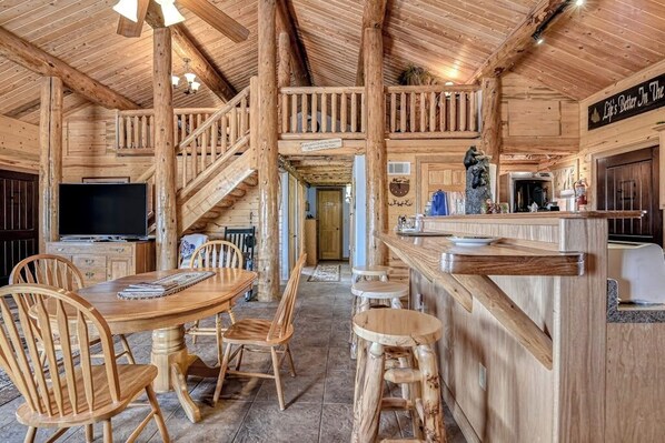A wooden interior with a dining area, a staircase, and a bar. - Remodeled, Dog-Friendly Cabin w/ Large Fenced Yard, WiFi & W/D - Great for ATVs (South Fork)