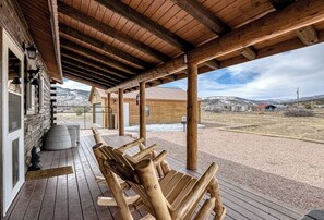 A wooden cabin with a covered porch, a bench, and a view of a snowy landscape. - Remodeled, Dog-Friendly Cabin w/ Large Fenced Yard, WiFi & W/D - Great for ATVs (South Fork)