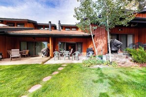 A modern house with a patio, outdoor seating, and a barbecue area. - Beautiful condo near the lifts with pool, WiFi, private washer/dryer (Steamboat Springs)