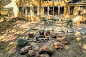A yellow house with a patio, outdoor seating, and a fire pit. - Posh mansion with antique decor, WiFi, & gas fireplace - near river and skiing (South Fork)