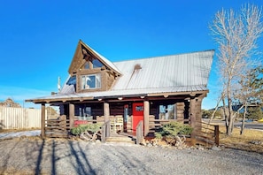 A rustic log cabin with a metal roof, a porch, and a red door. - Classic alpine cabin with fast WiFi, enclosed yard, deck, dogs ok (South Fork)