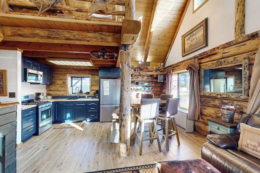 L’intérieur d’un chalet rustique comprenant une cuisine, un coin repas et un salon.