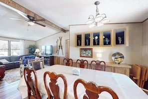 Ein Essbereich mit Tisch, Stühlen, Deckenventilator und wandmontierten Schränken.
