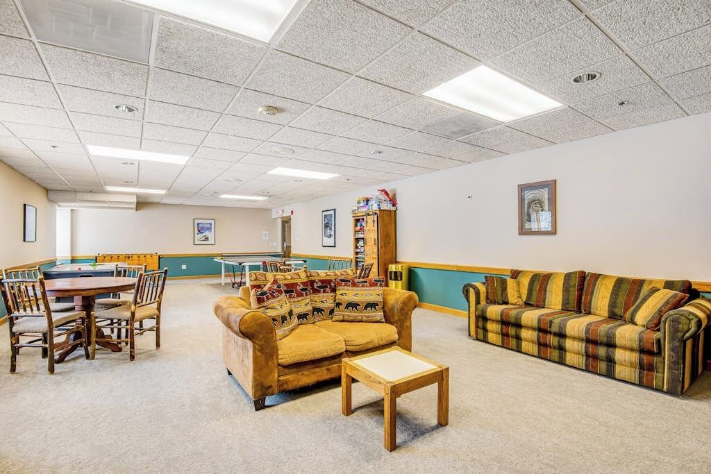 A room with a pool table, a sofa, a couch, and a small table.