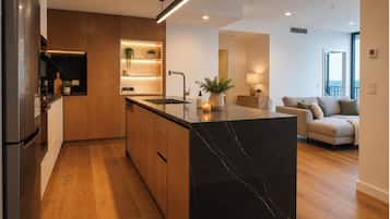 A modern kitchen with a marble island, wooden cabinets, and built-in appliances.