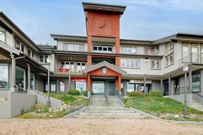 A multi-story building with a central clock tower, a staircase leading to the entrance, and a sign indicating a tower hotel. - Luxury home one block from gondola w/mountain views, free WiFi, & private W/D (Steamboat Springs)