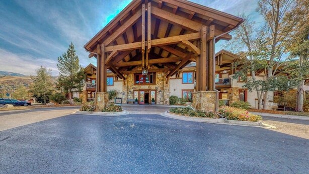 A lodge with a covered entrance, stone walls, and a view of the surrounding landscape. - EagleRidge Lodge 209 Inviting, walk-to-lift condo w/ fireplace & shared pool/hot tubs/gym/shuttle (Steamboat Springs)