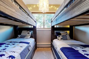 A room with bunk beds, a chandelier, and a window with a view. - Updated, Top-Floor Condo w/ Gas Fireplace, Shared Pool/Hot Tub - Walk to Shuttle (Steamboat Springs)