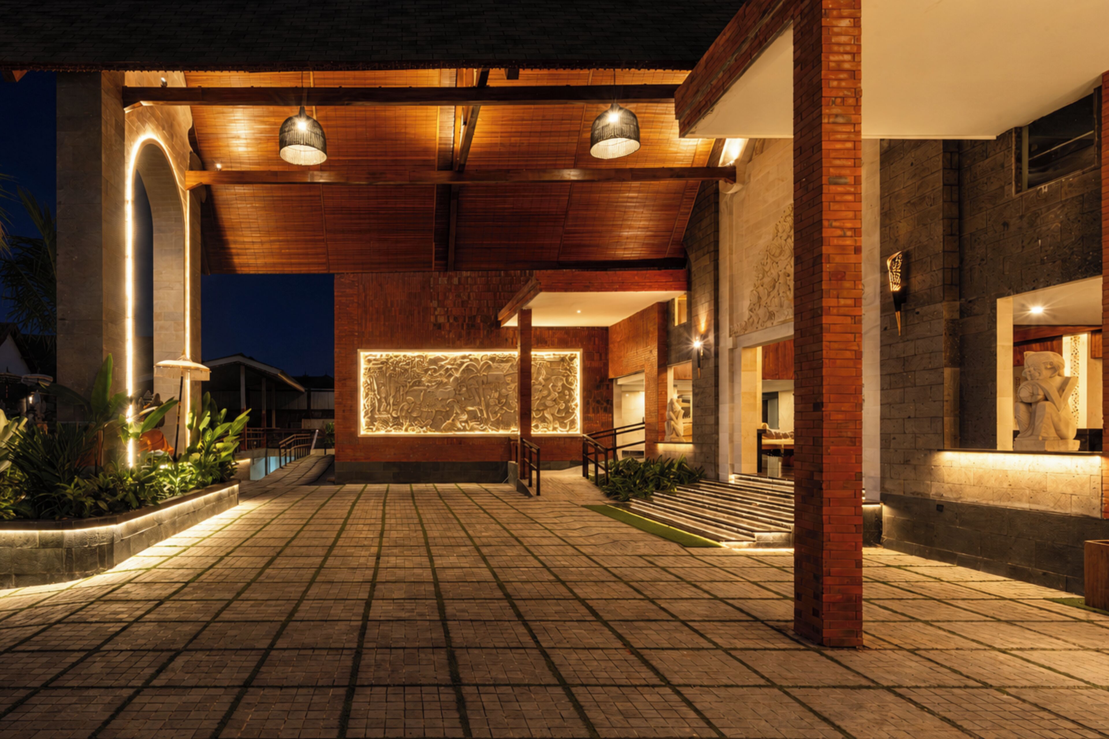 A spacious outdoor area with a tiled floor, a wooden ceiling, and a wall with a lighted design.