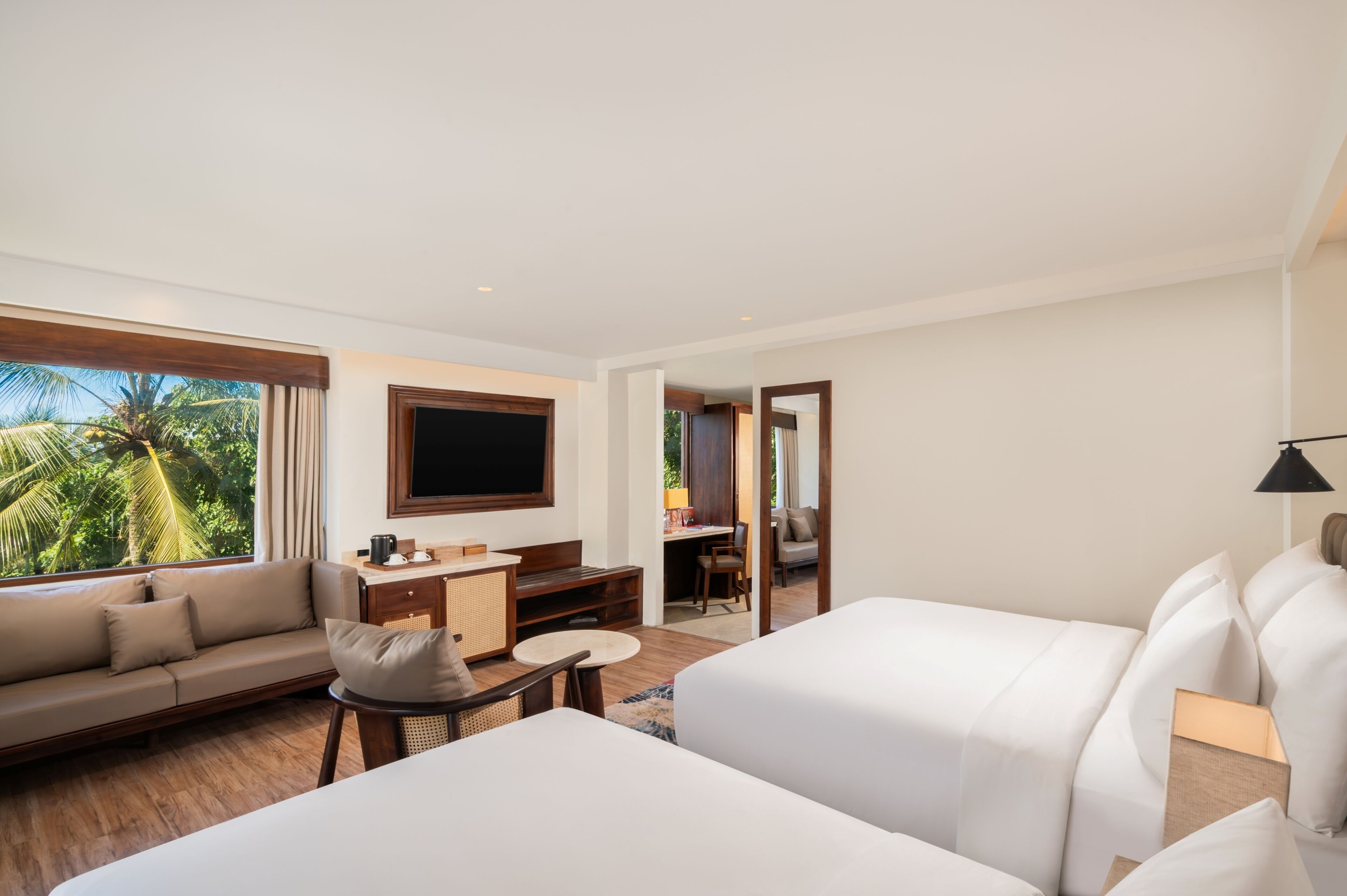 Een moderne hotelkamer met een bank, een bed, een bureau en een televisie.