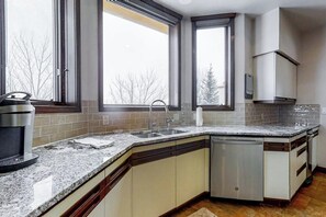 A kitchen with a granite countertop, stainless steel appliances, and a dishwasher. - Ultimate mountain penthouse with hot tub, fitness, pool, & winter shuttle (Steamboat Springs)